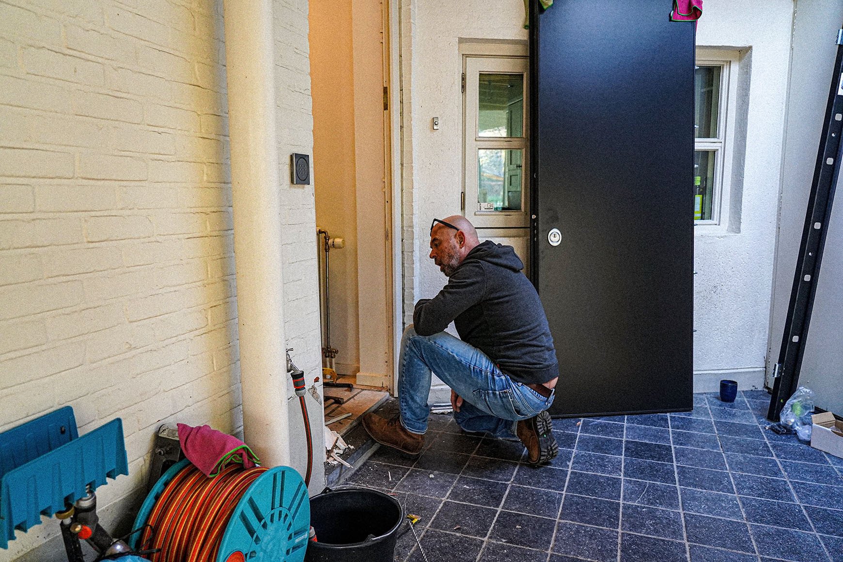 Dimitri Van de Merlen van Polderse Sloten tijdens de plaatsing van een stevige veiligheidsdeur voor extra woningbeveiliging.