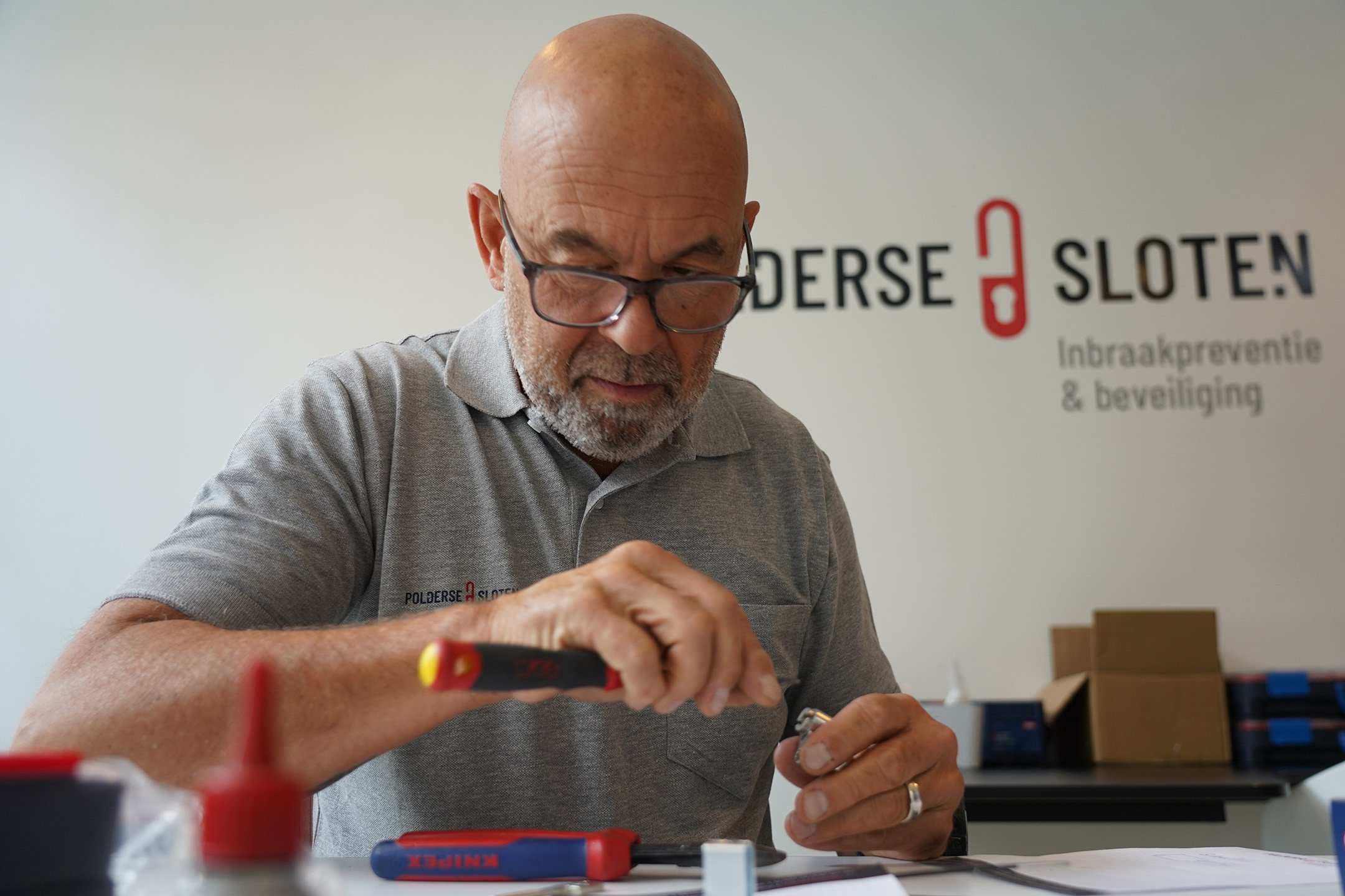 Dimitri Van de Merlen werkt aan een slot in de werkplaats van Polderse Sloten, specialist in sloten, beveiliging en inbraakpreventie.